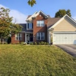 brown-house-with-trees-in-front-green-lawn
