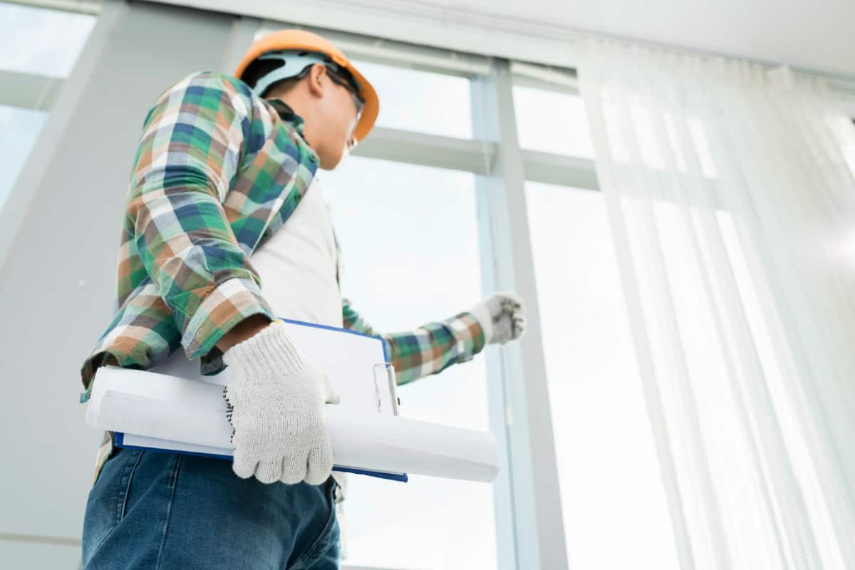 Male inspector looking at home improvement project that require building permit