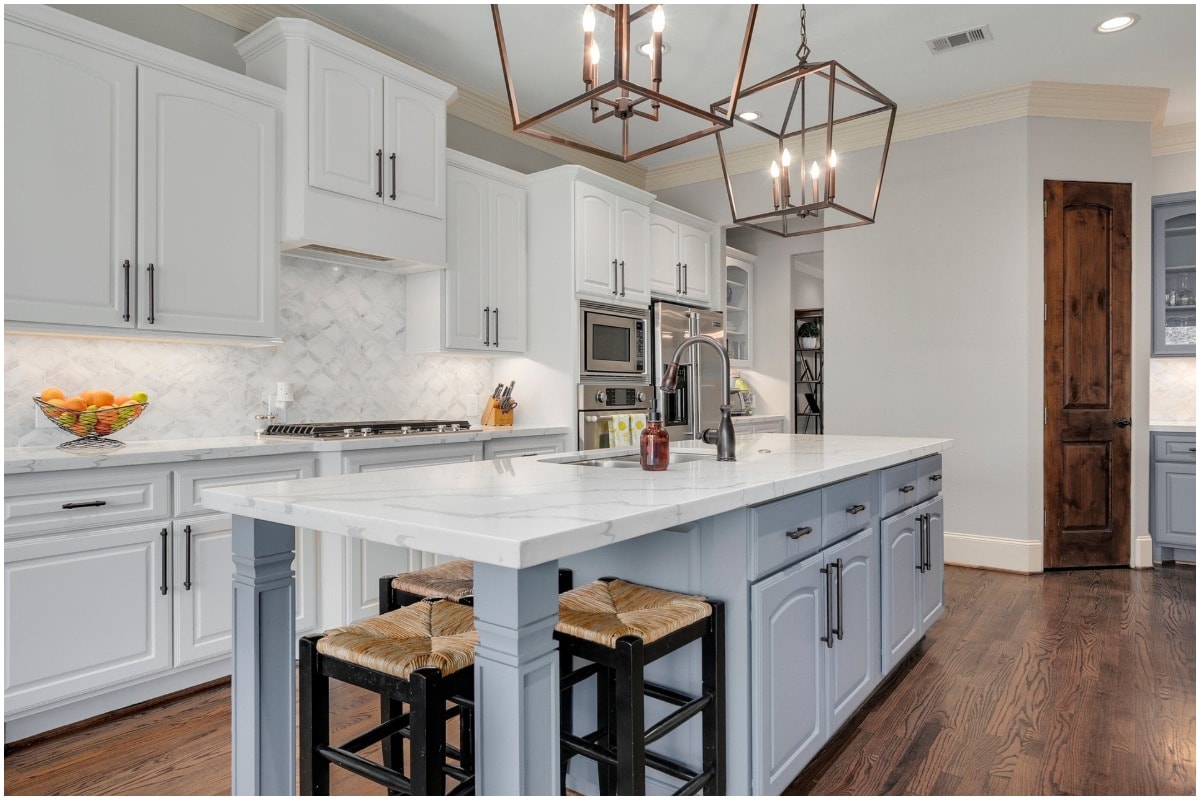 white kitchen marble countertops light blue cabinetry woven stools