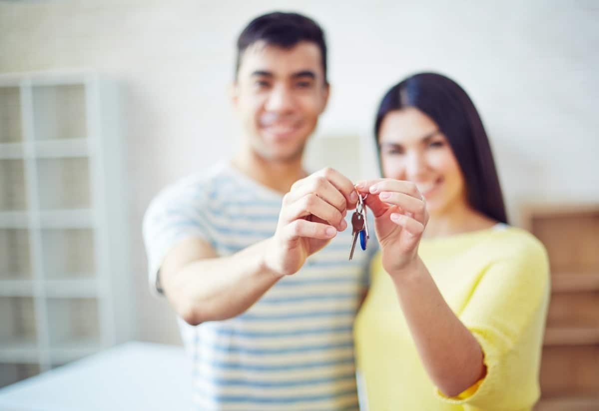 Young couple holding key from new flat