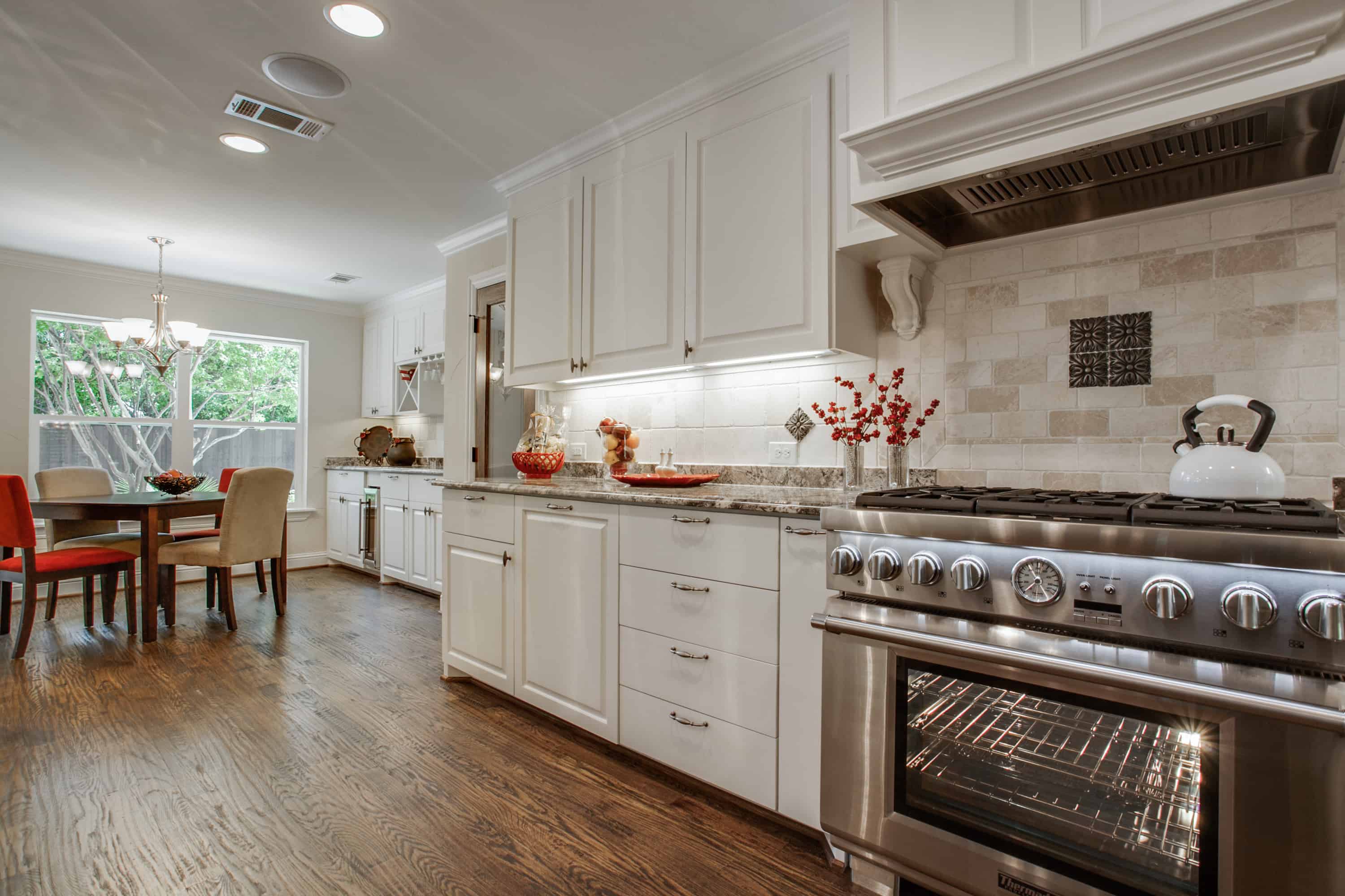 Open kitchen with white cupboards and a tiled backsplash