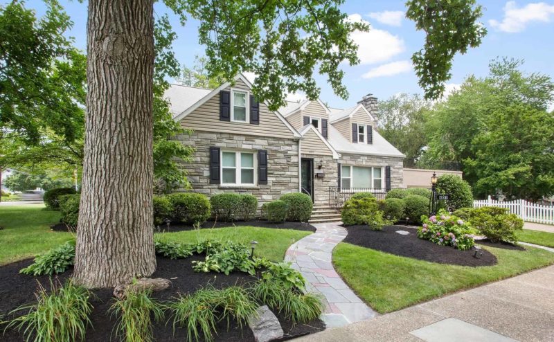 Craftsman home with landscaping trees and shrubs