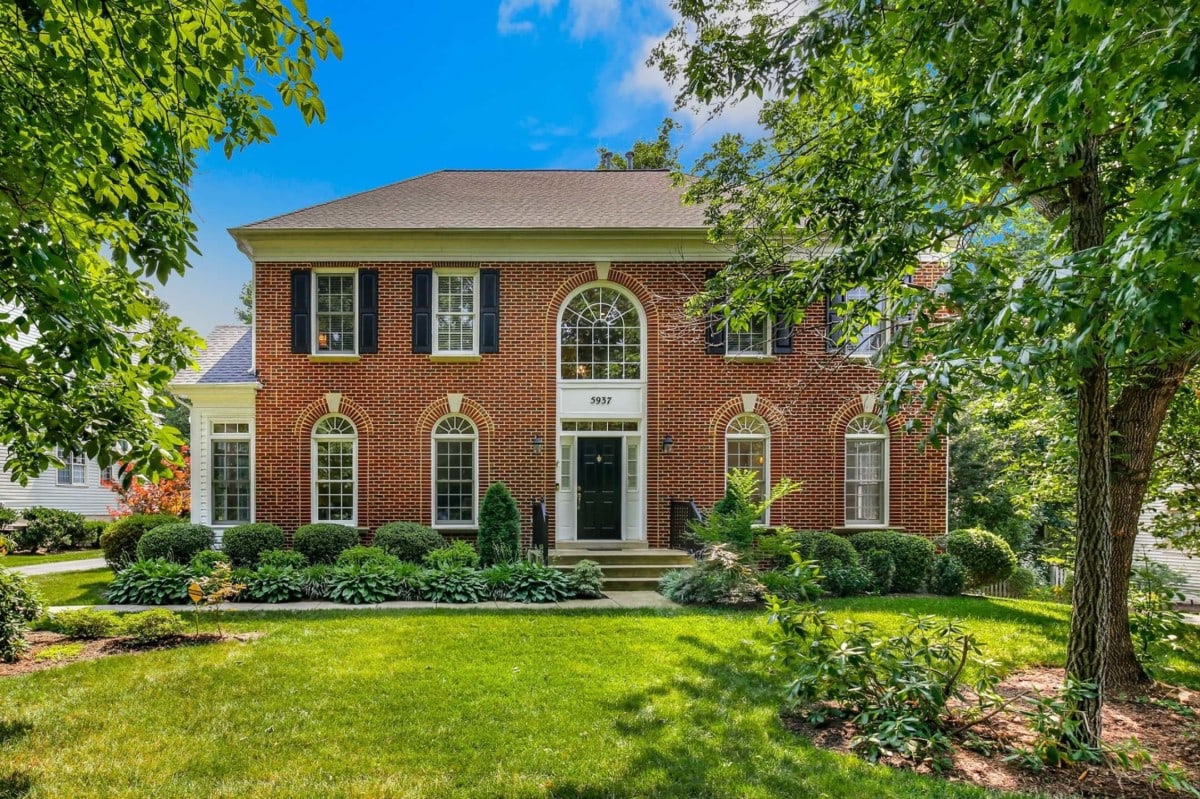 Two story, brick colonial style homes with dark blue shutters