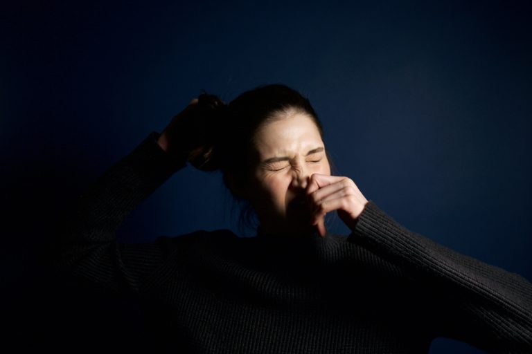 woman sneezing from allergies