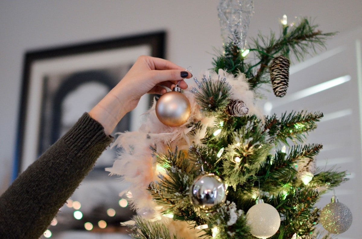 Woman decorating the Christmas tree with ornaments