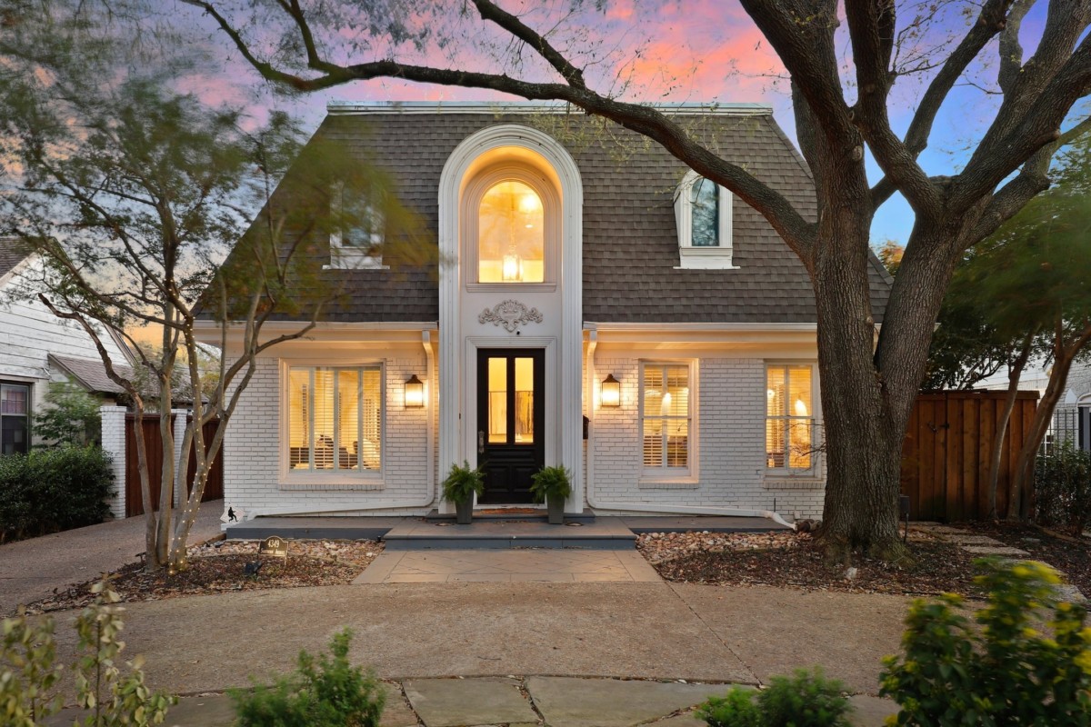 A one-story white house with a rounded entryway and decorative windows.