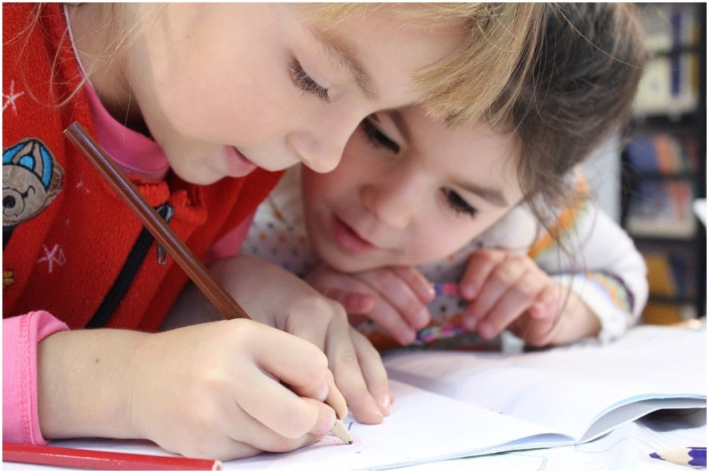 two children doing writing during homeschool 