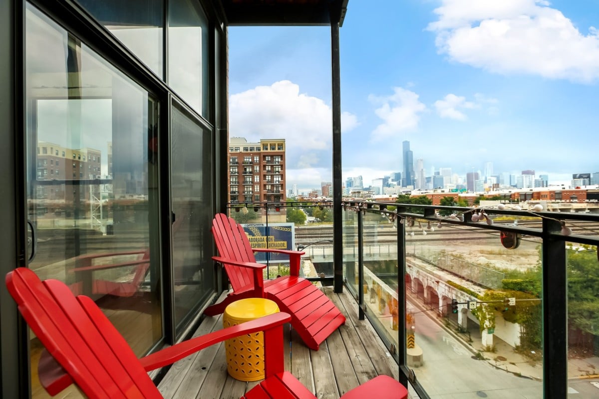 Condo patio with red chairs with a city view