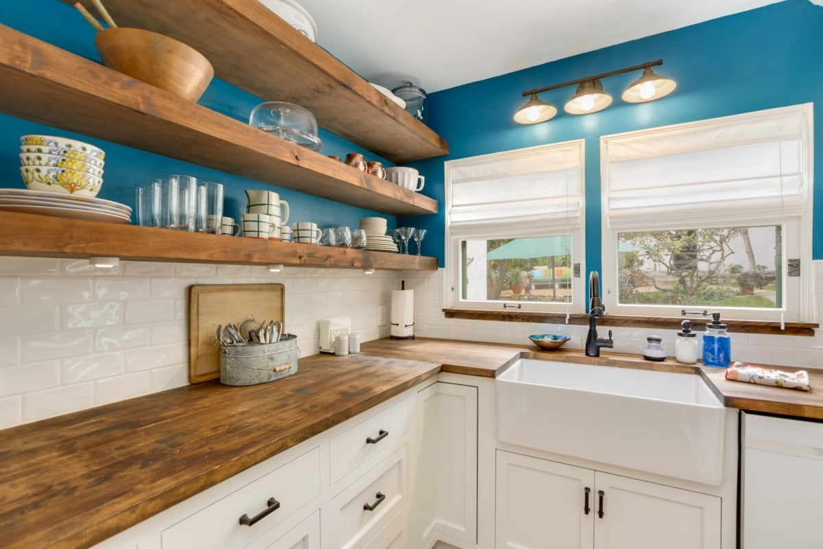 white cabinet kitchen wood shelves blue wall