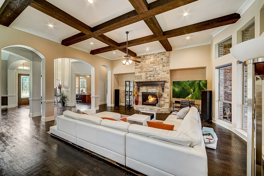 wood beam ceilings white couch brick fireplace 