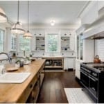 Clean kitchen with woodblock island and black stove