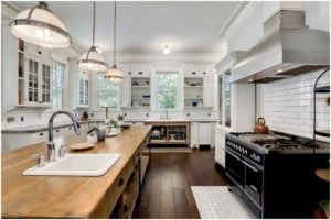 Clean kitchen with woodblock island and black stove