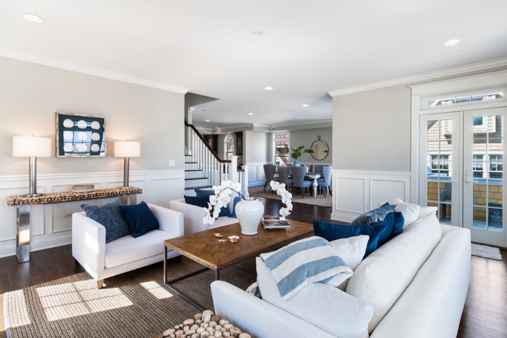 Decluttered living room with white couches and chairs with blue toss pillows and all ready for the home appraiser.