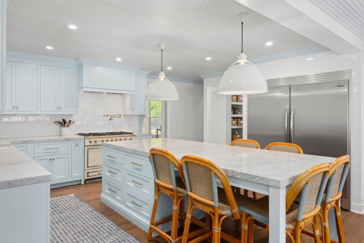 A large kitchen with gold accents and light blue cabinets