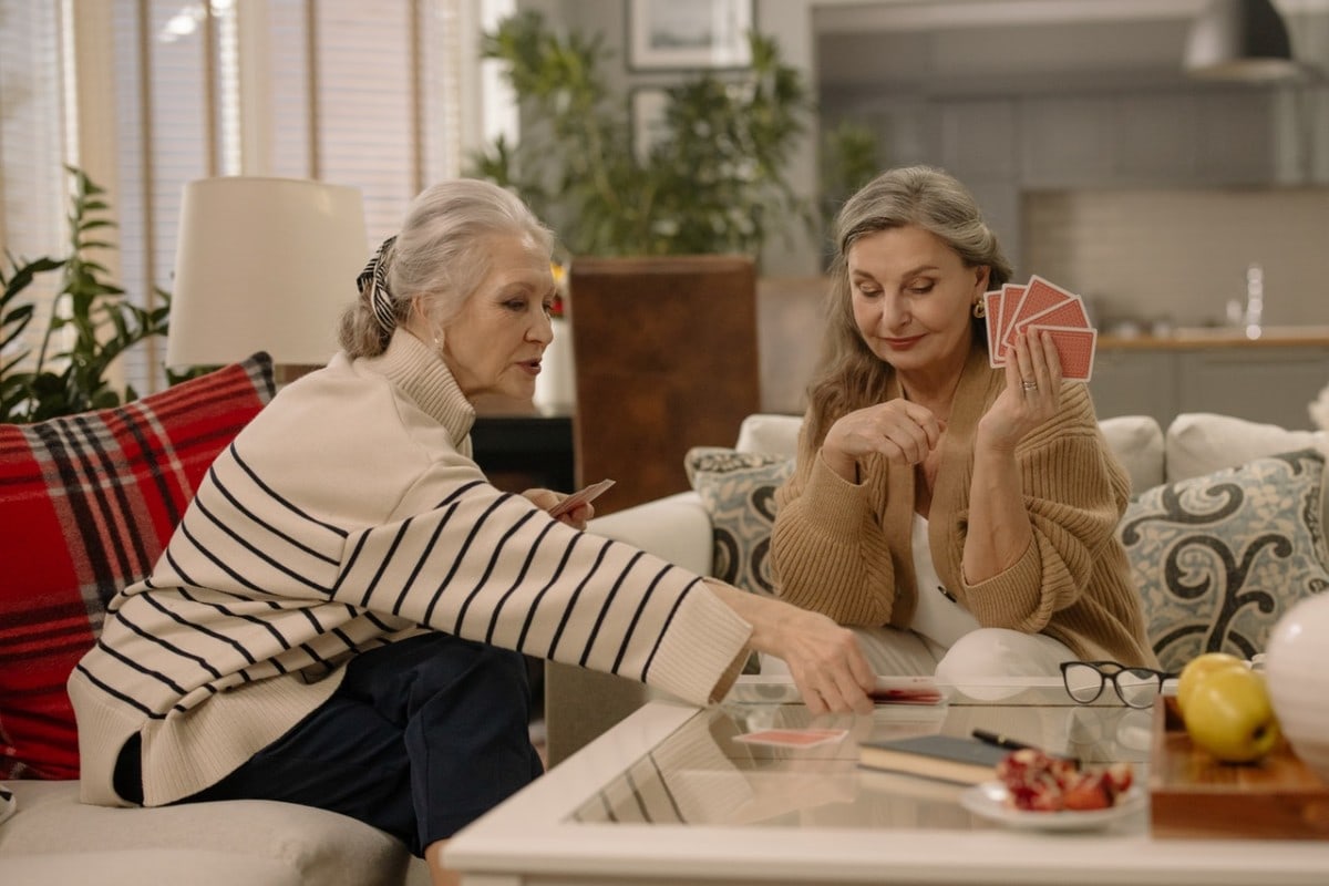 Two women playing cards with eachother