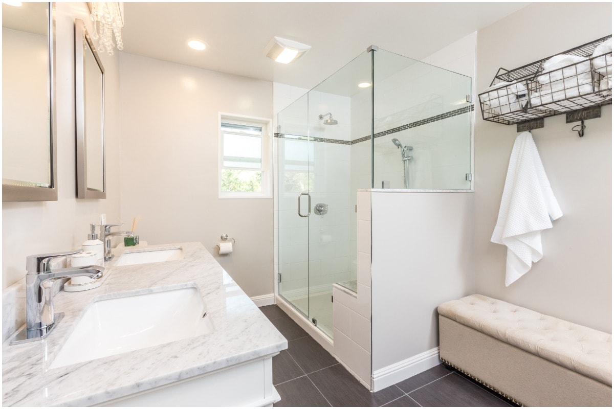 A bright, white bathroom with a corner shower