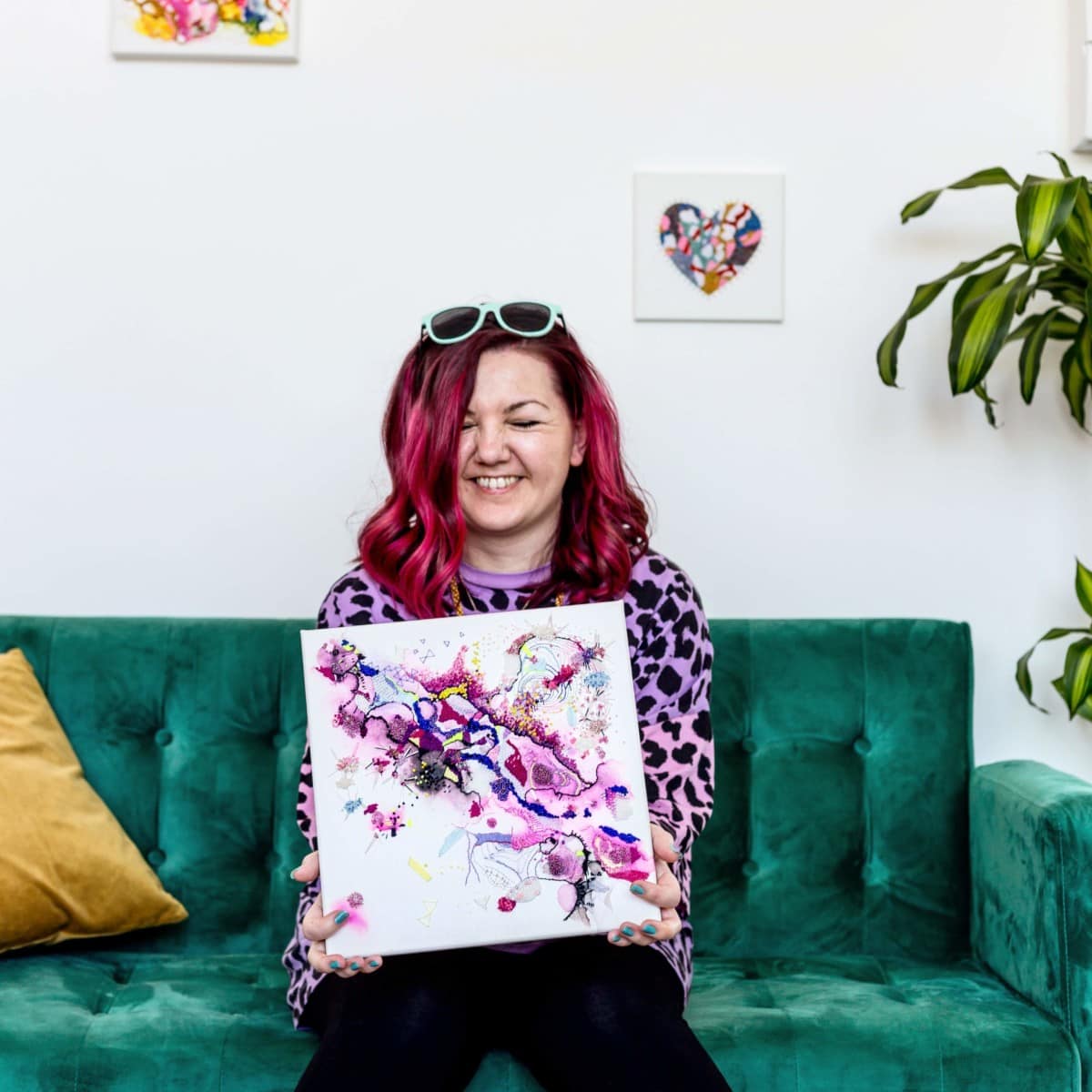 woman-holding-splatter-paint-art-on-green-couch