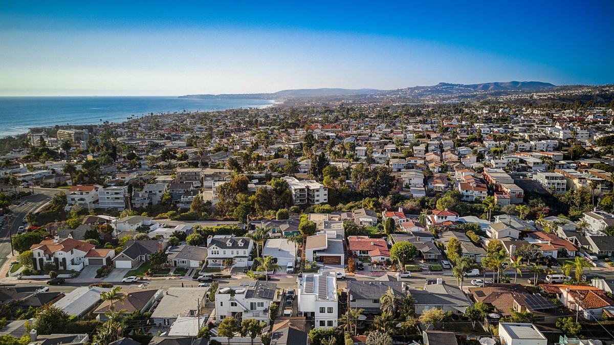 drone photo of houses in a neighborhood with the ocean 