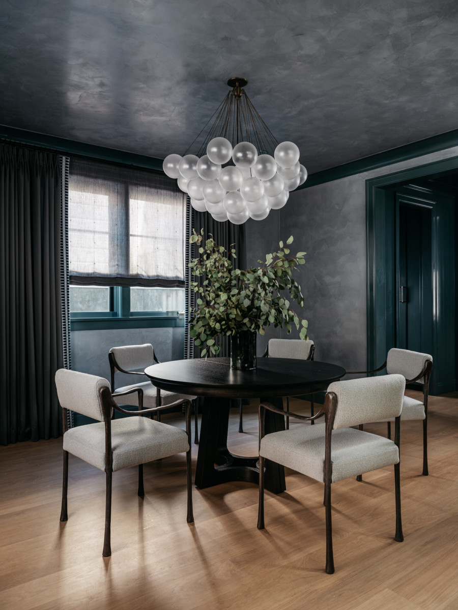 dark dining room with white chairs and dark walls