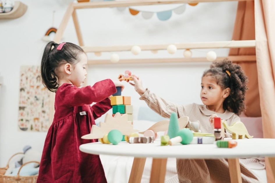 Two kids playing with toys on a table