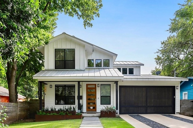 affordable austin suburbs home with white exterior and black garage door