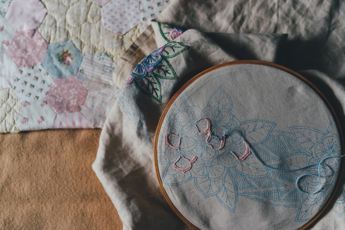 Cross stitch project using white, pink, and blue thread
