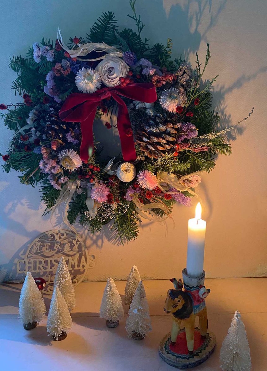 wreath with candles, small white trees, and a red bow