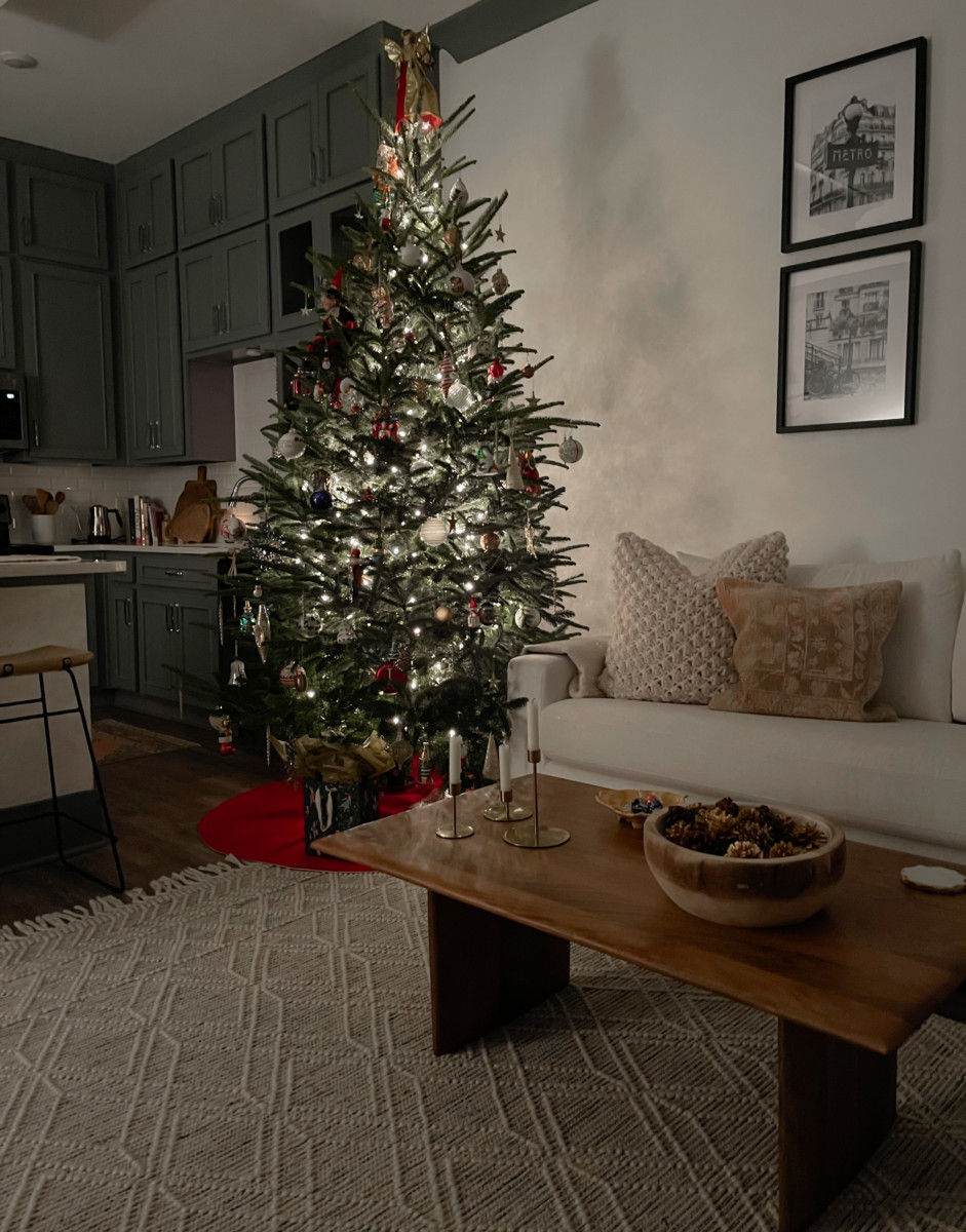 cozy living room with simple holiday decorating including a tree and light furniture
