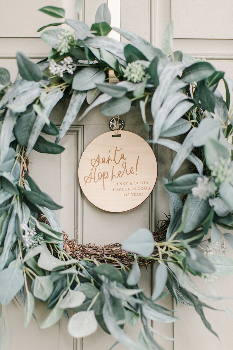 wreath on front door with engraved personalized sign in the middle