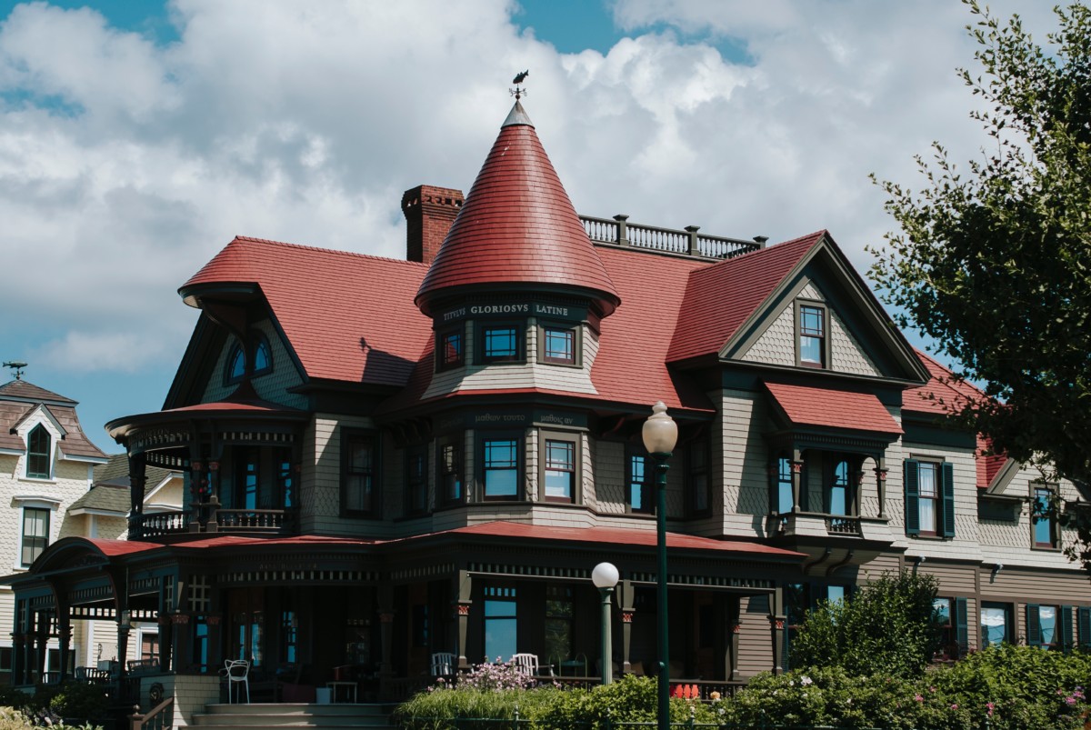 richardsonian romanesque victorian home with turret and reddish brown exterior