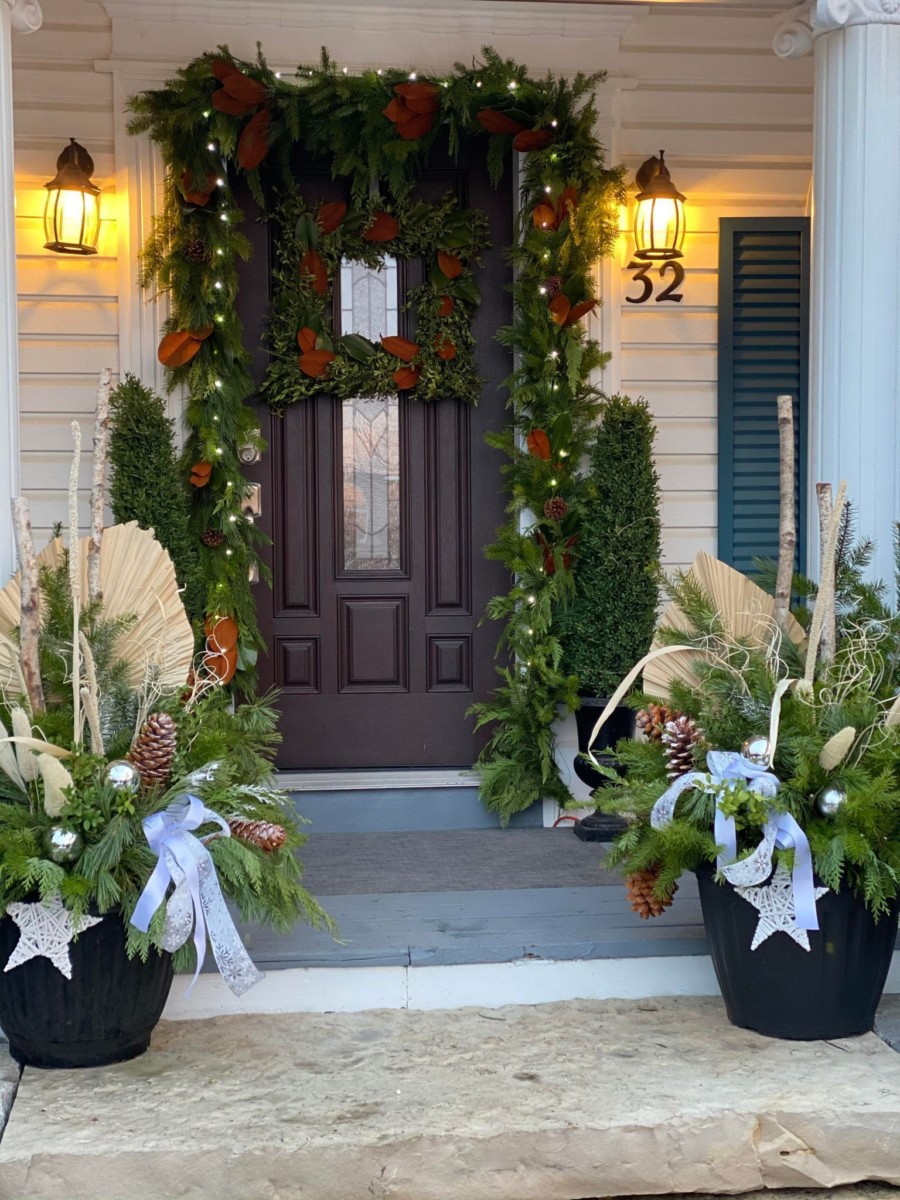 front door decorated with lots of plants and trim