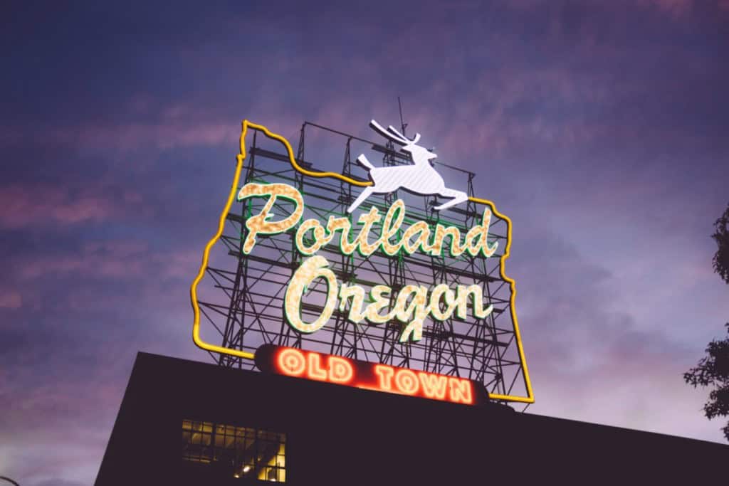 portland oregon sign at dusk with a deer and the oregon state outline