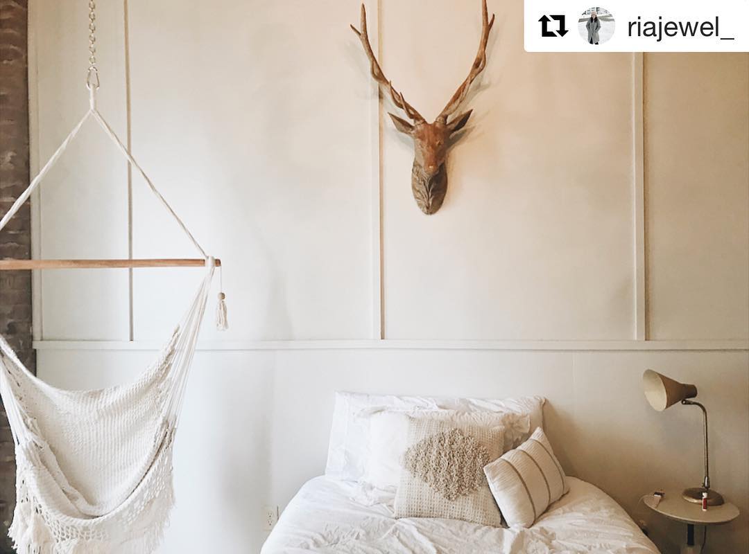 white walls with a macrame white hammock