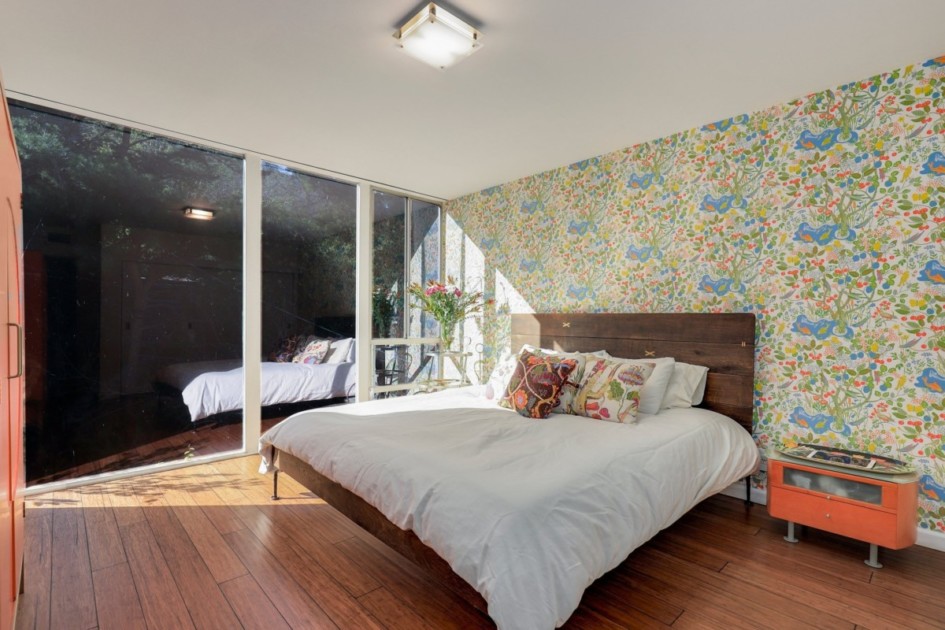 Bedroom with colorful wallpaper and pillows