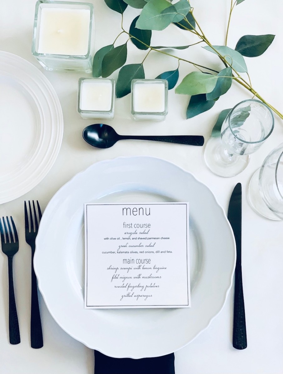 placecards on a dining table with bits of greenery