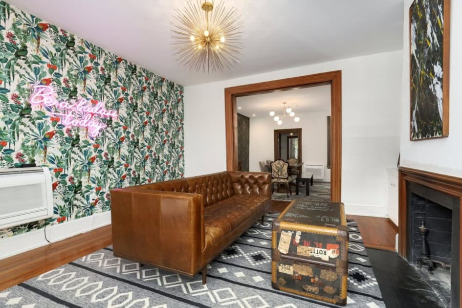 Neon wall art with wallpaper and a leather couch