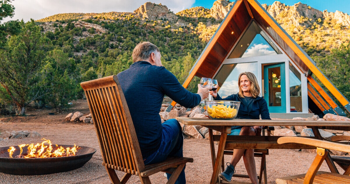 couple sharing dinner outdoors with tiny home _ getty