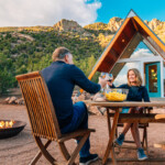 couple sharing dinner outdoors with tiny home _ getty