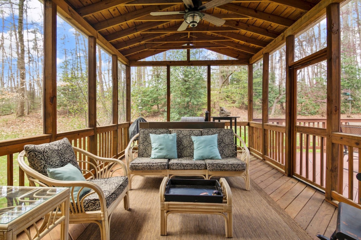 enclosed porch with seating in a backyard