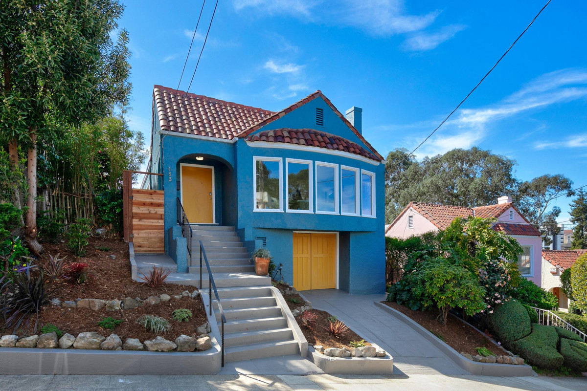 outside of a home with blue exterior and yellow doors