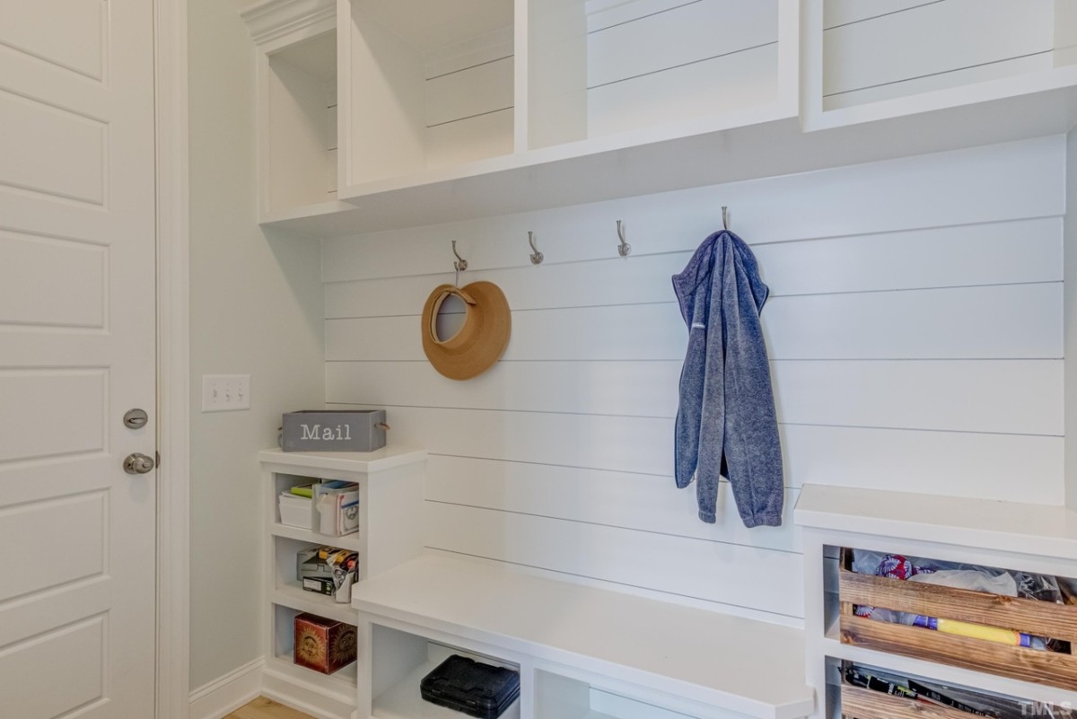 entryway for an organized apartment with hanging hooks and storage