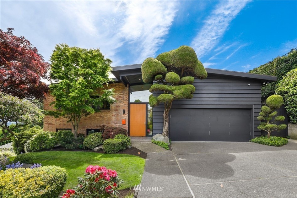 A mid century modern house with dark exterior and brick