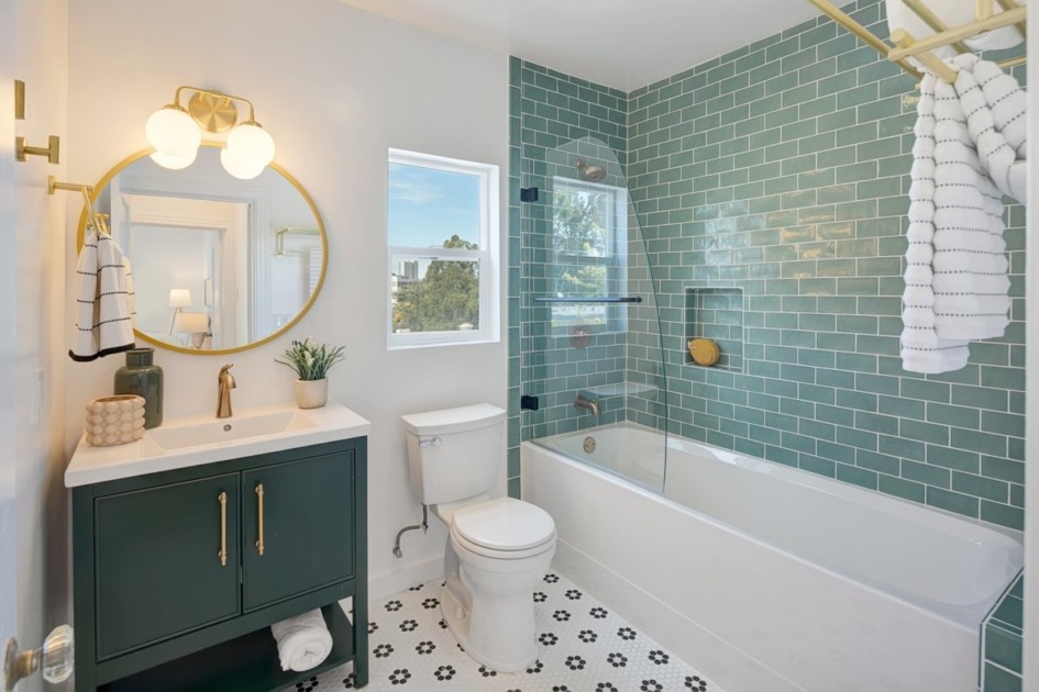 An apartment bathroom with colorful tile and cabinets