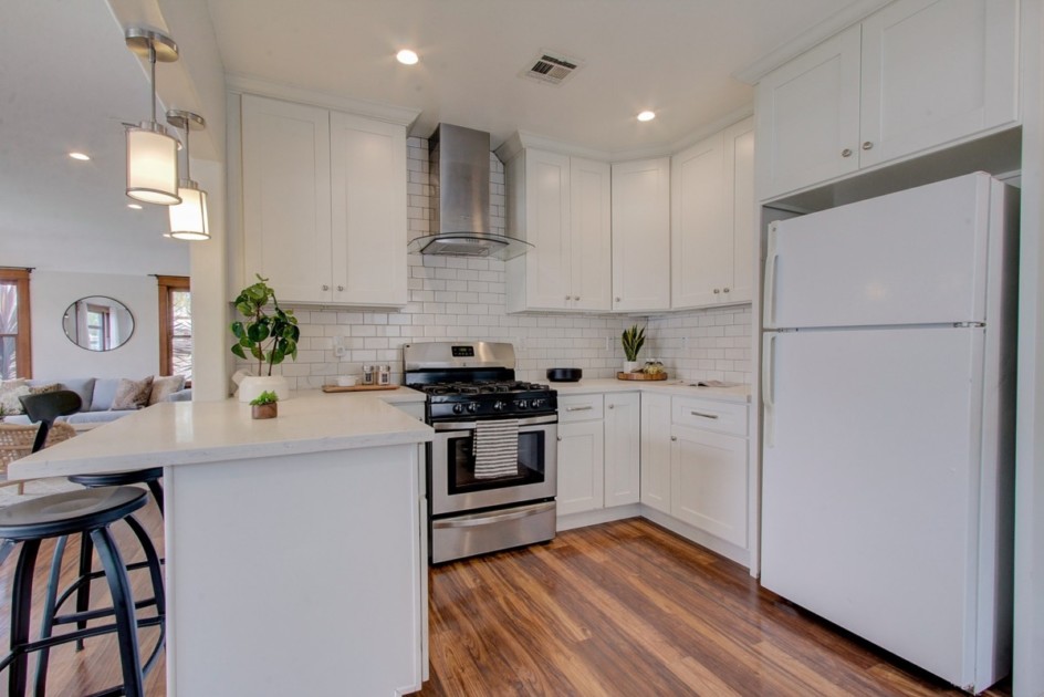 A clean apartment kitchen white white countertops and cabinets