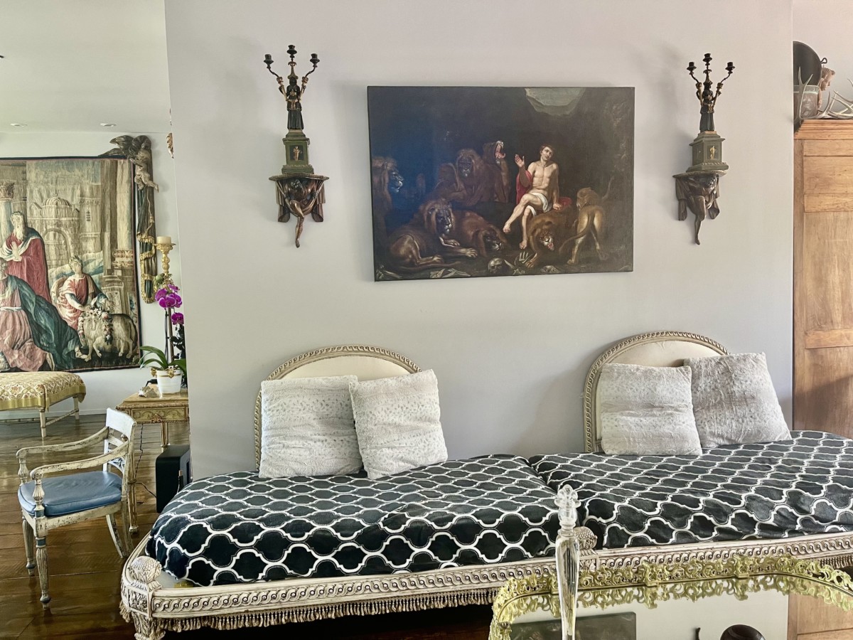 reupholstered antique couch with older paintings