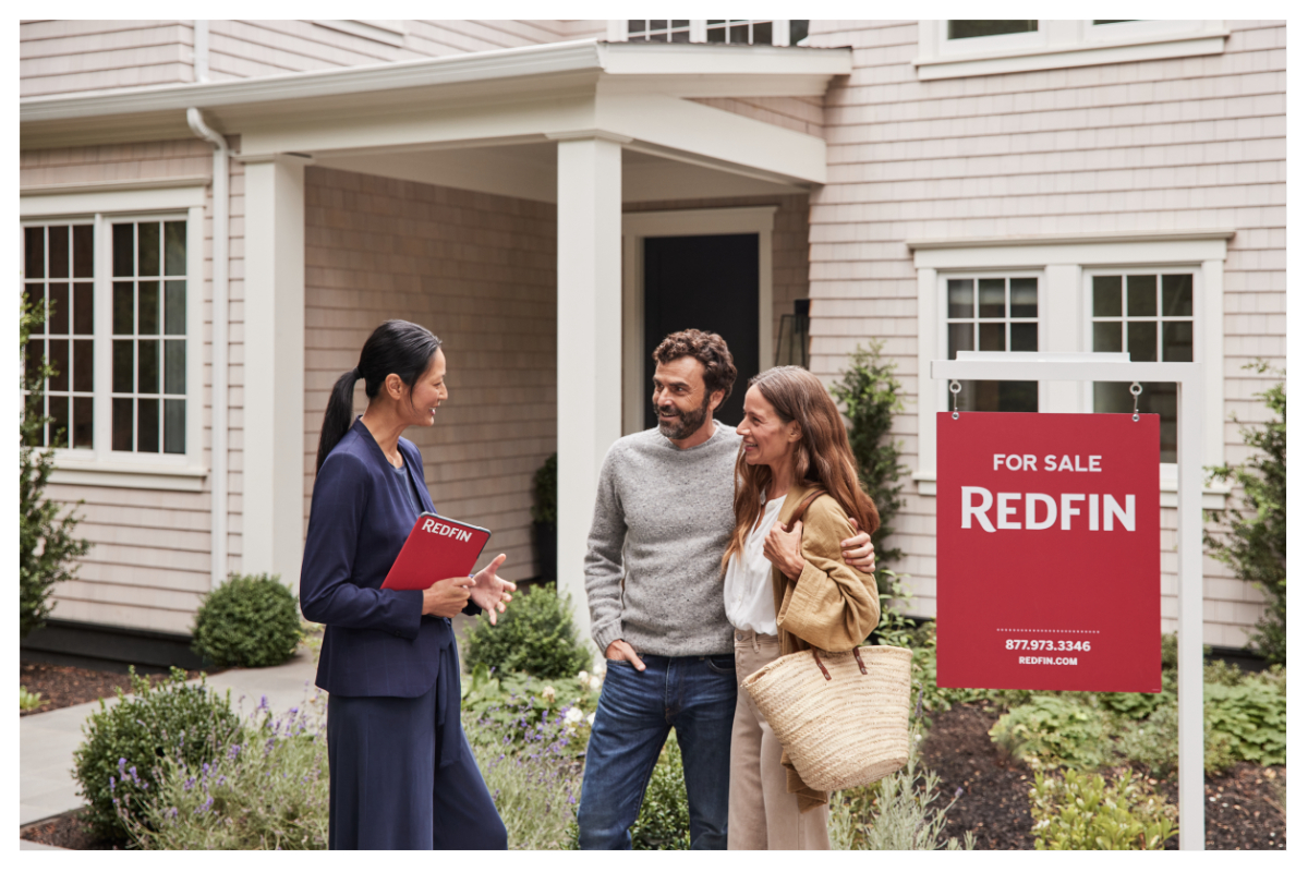 An agent talks to people outside a house