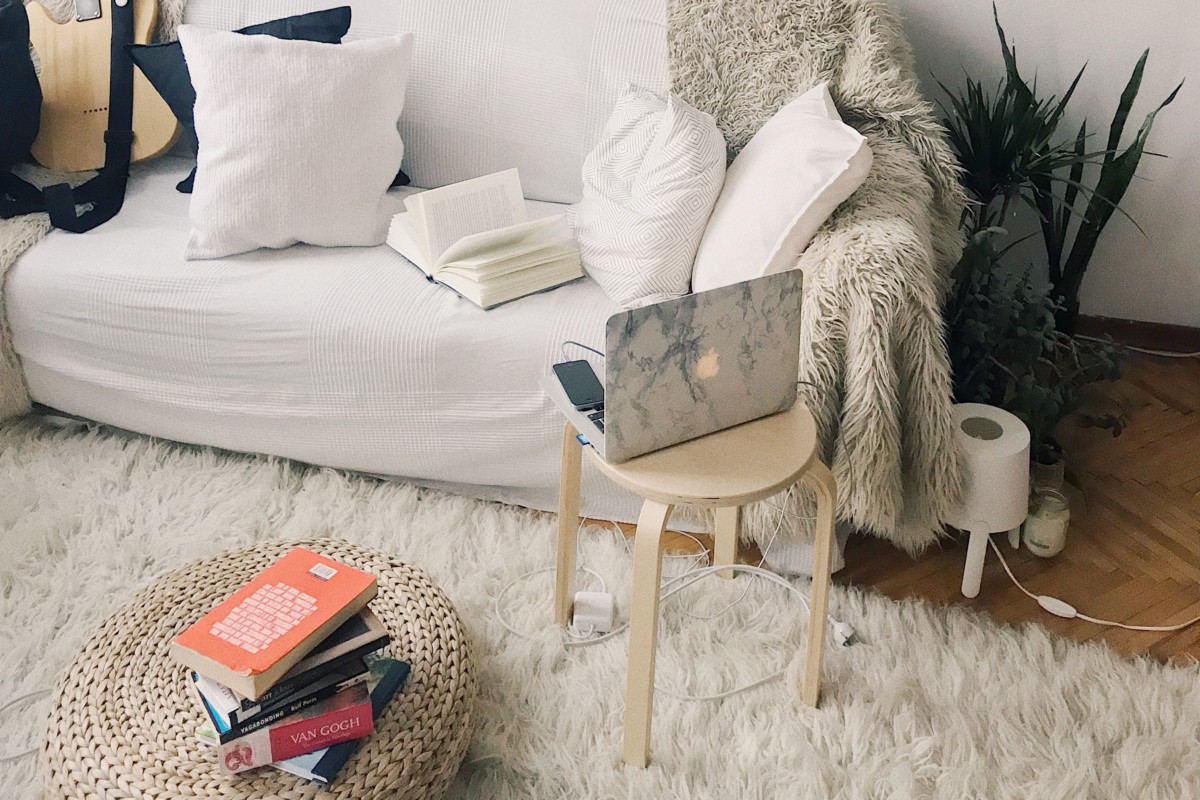 white couch with books and a laptop