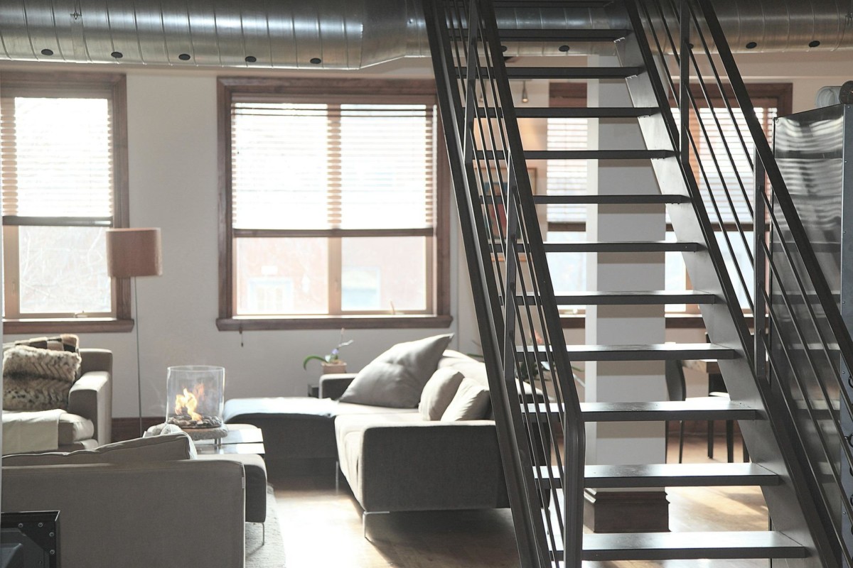 industrial condo living room with stairs to second floor