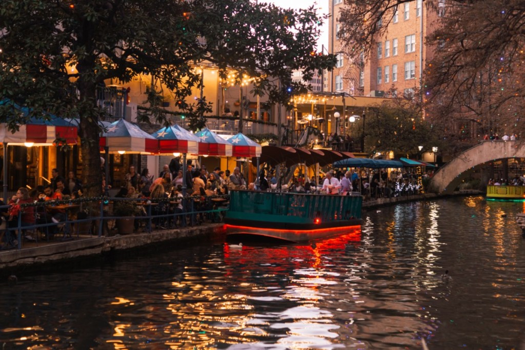 san antonio texas riverwalk with a boat and lots of people
