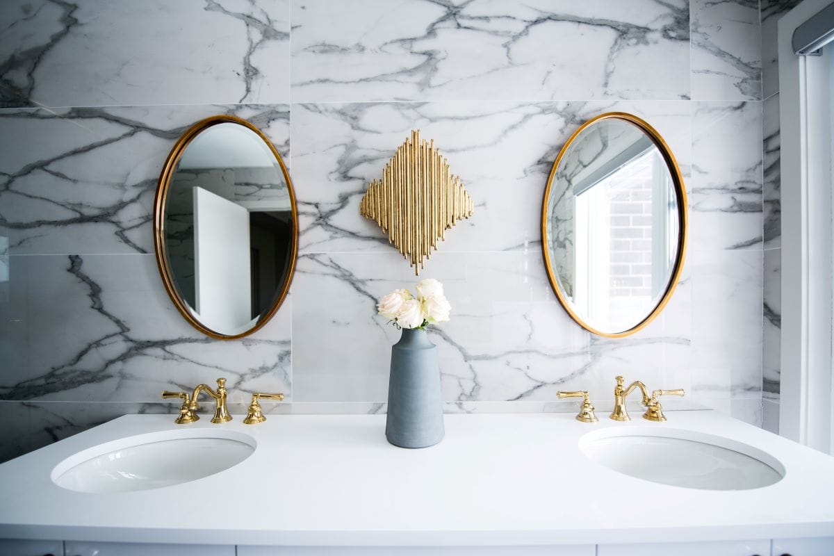 white bathroom counter with gold faucets